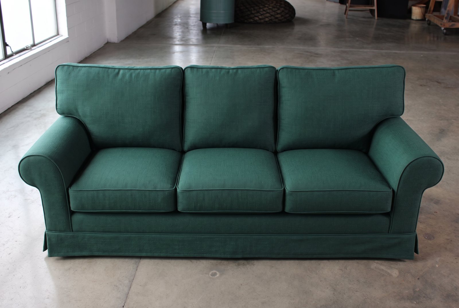 Dasselbe Sofa nach dem Neubezug mit tannengrünem Stoff